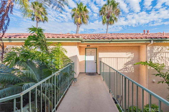 Front view of a house with a tiled roof and a walkway leading to the entrance.