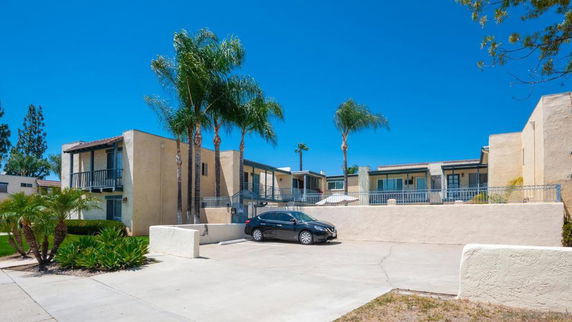 Outdoor parking area in front of a two-story apartment building