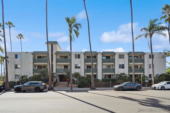 Front view of a multi-story apartment building with balconies.