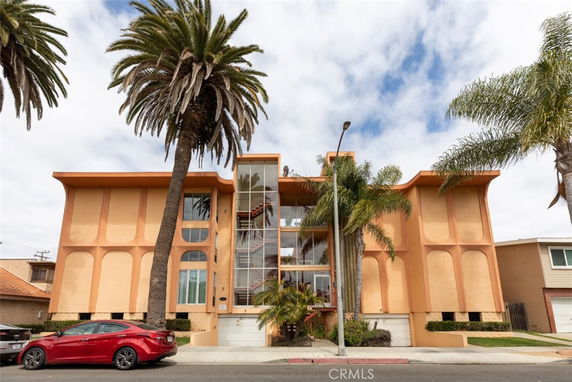 Front view of a multi-story building with unique geometric patterns and palm trees.
