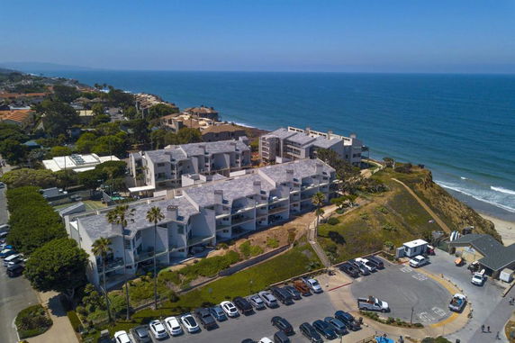 Aerial view of apartment complex near the coastline overlooking the ocean.