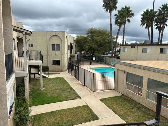 Outdoor area with a swimming pool surrounded by residential buildings.