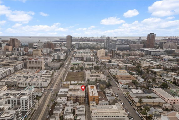 Aerial view of an urban landscape with numerous buildings, roads, and a distant view of the coastline.
