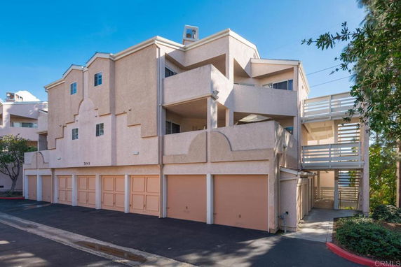 Front view of a multi-story building with multiple garages and balconies.