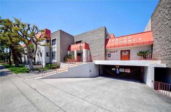 Front view of a multi-story building with signage 'Rancho Downey' and an entrance ramp.