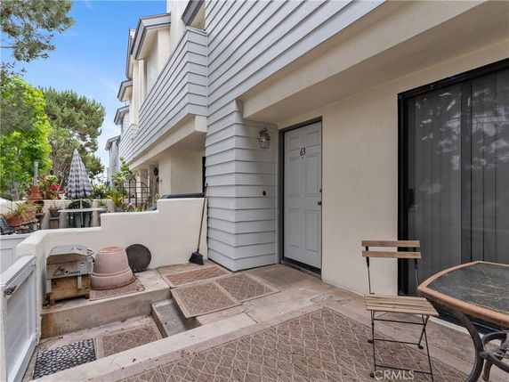 Front view of a multi-level house with a small patio area and entrance.