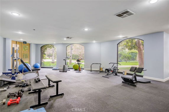 Indoor gym area with exercise equipment and large windows.