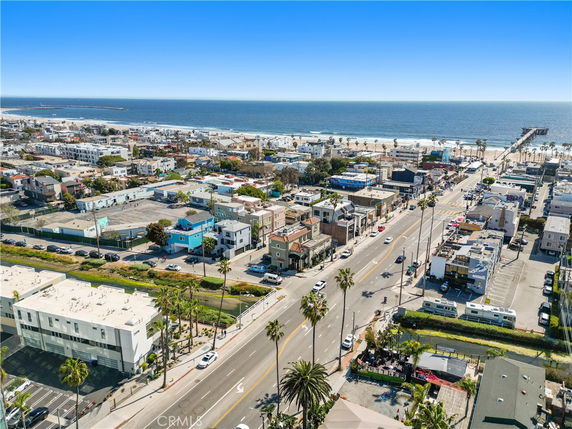 Panoramic view of a coastal town with buildings, roads, and beach in the background.