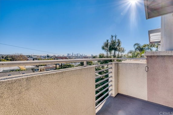 Panoramic view from a building balcony overlooking a city skyline.