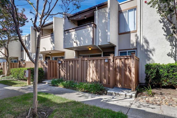 Front view of a two-story townhouse with a fenced front entrance.