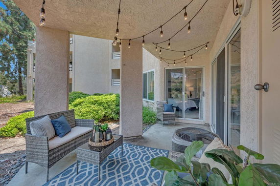 Outdoor patio area with seating and string lights.