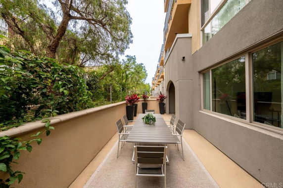Outdoor area with dining table alongside a modern building facade.