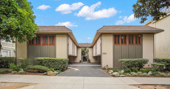 Front view of a two-story building with a driveway and distinctive design.
