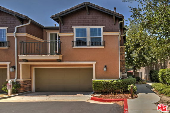 Front view of a two-story townhouse with a double garage and balcony.