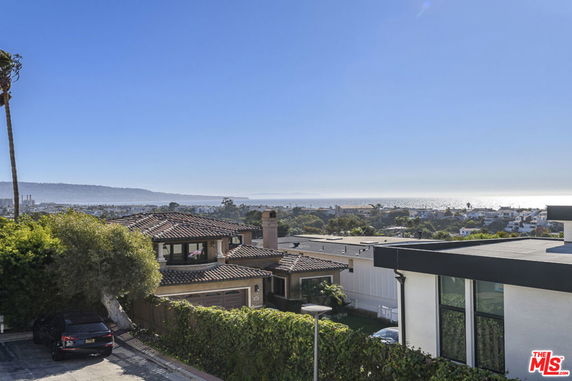 Panoramic view of a residential area with houses overlooking the ocean.