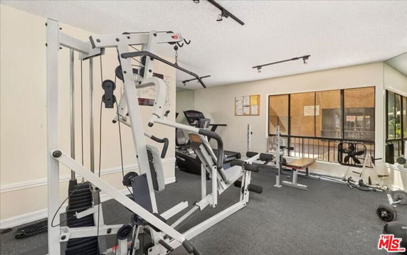 Indoor gym area with exercise equipment and large windows