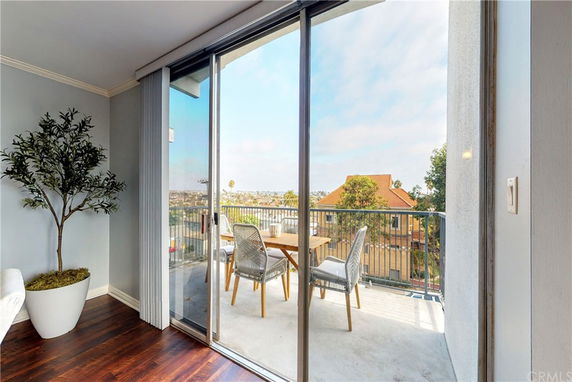 View from an apartment balcony with seating, overlooking a residential area.