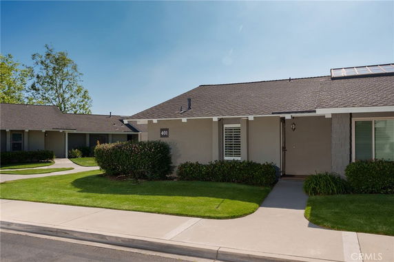 Front view of a single-story house with a sloped roof and a path leading to the entrance.