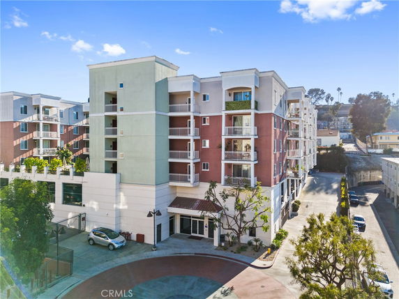 Front view of a multi-story apartment building with balconies.