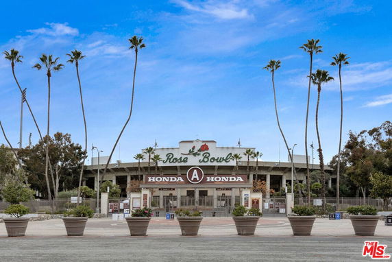 Front view of a stadium entrance with palm trees.