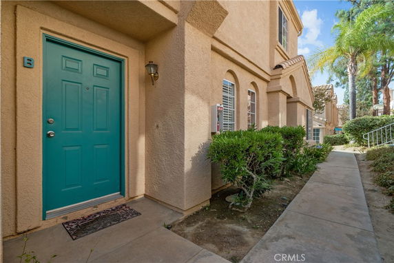 Front view of a house entrance with a blue door and light-colored exterior walls.
