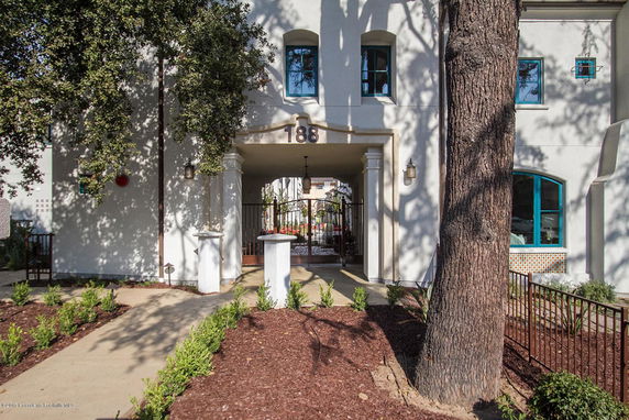 Front view of a building entrance with columns and gated archway.