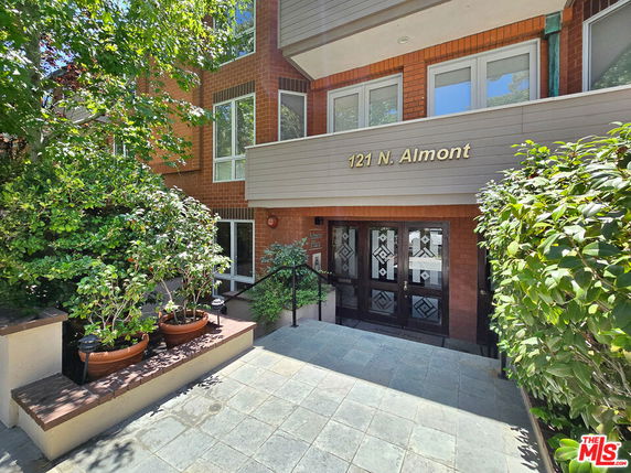 Front entrance of a brick building with the address 121 N. Almont.