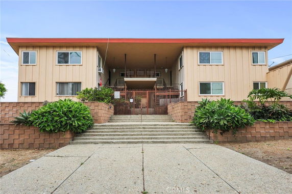 Front view of a two-story building with a central entrance and stairs leading up.