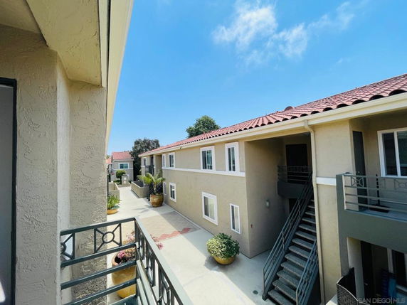 View of a multi-story building with a courtyard and outdoor stairs.