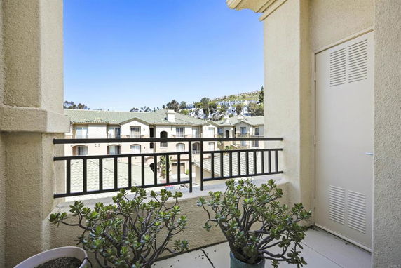 View from a balcony overlooking residential buildings and greenery.