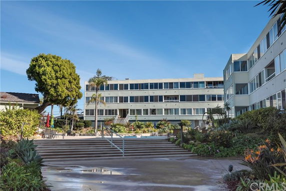 Front view of a multi-story residential building with large windows.