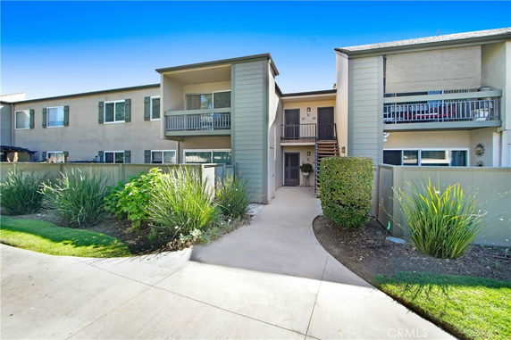 Front view of a multi-unit residential building with balconies and a central entrance.