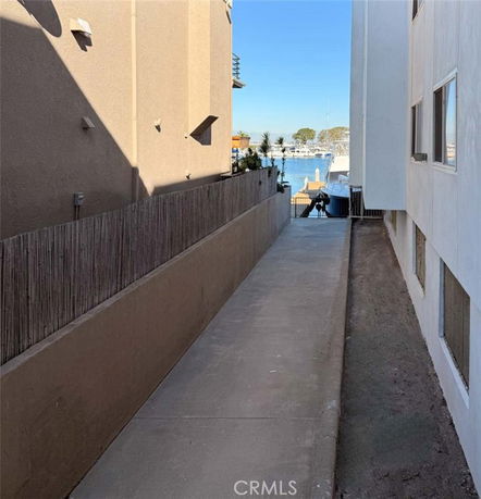 View between two buildings leading to a waterfront area with boats.