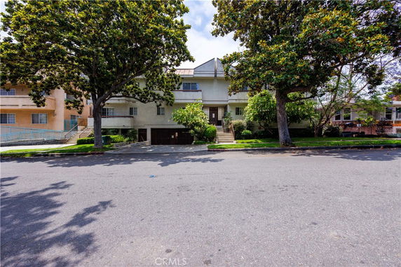 Front view of a two-story residential building with trees in front.