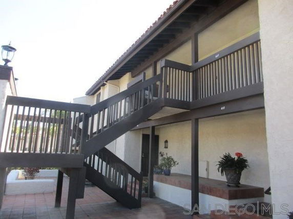 Front view of a building with an outdoor staircase and balcony.