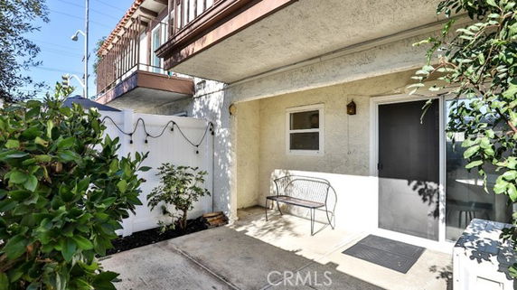 Front view of a house with an outdoor bench and potted plants.