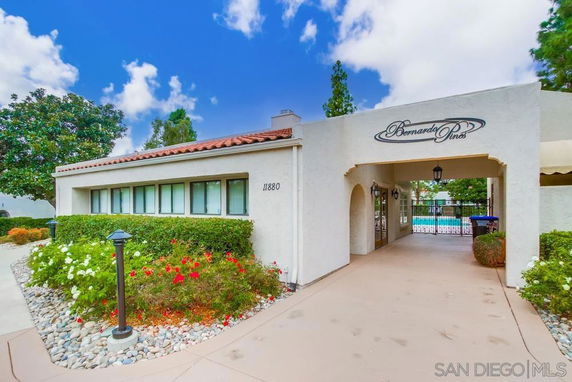 Front view of a building with a covered entrance and landscaped garden.