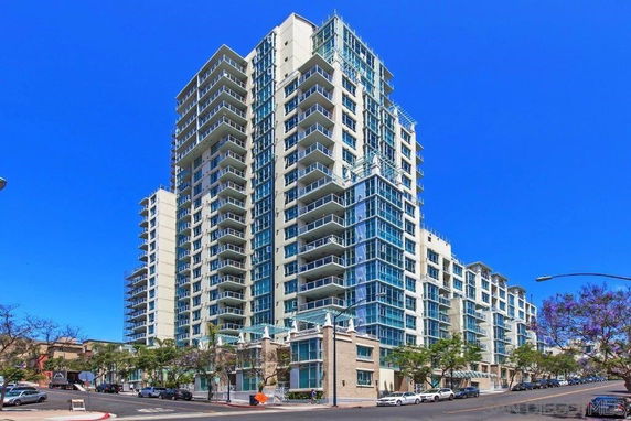 Front view of a multi-story residential building with glass balconies.