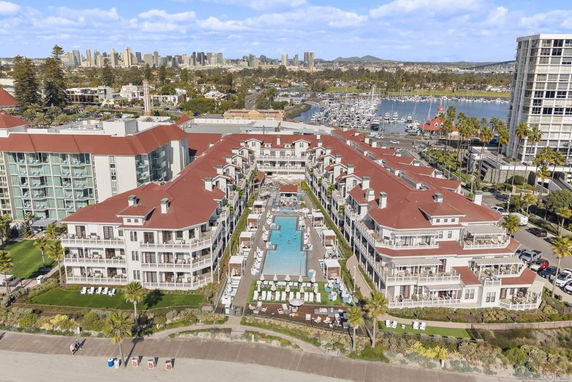 Aerial view of a large, multi-story building complex with red roofs and multiple balconies.