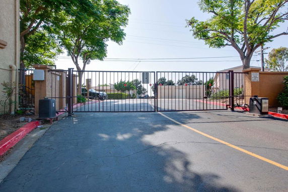 Entrance view with a closed gate and surrounding trees.