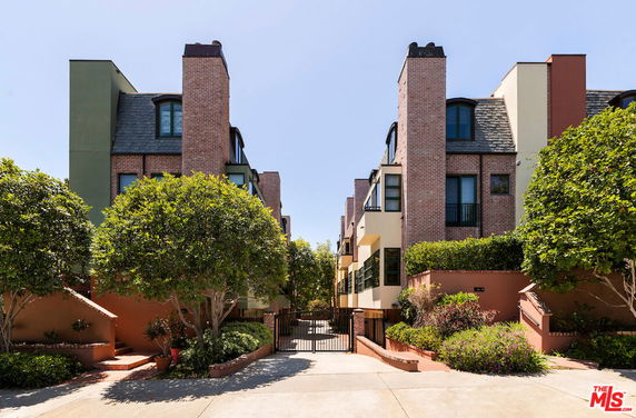 Front view of a multi-story residential building with brick and stucco exterior.
