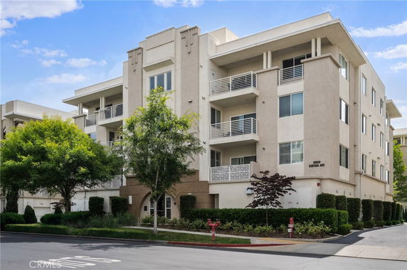 Front view of a four-story apartment building with balconies.