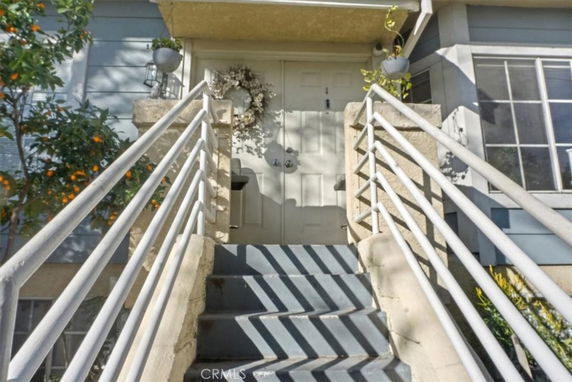 Front entrance of a house with stairs leading to a door.