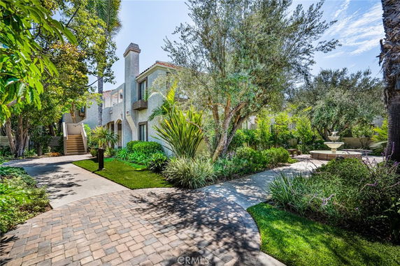 Front view of a house with a garden and a fountain.