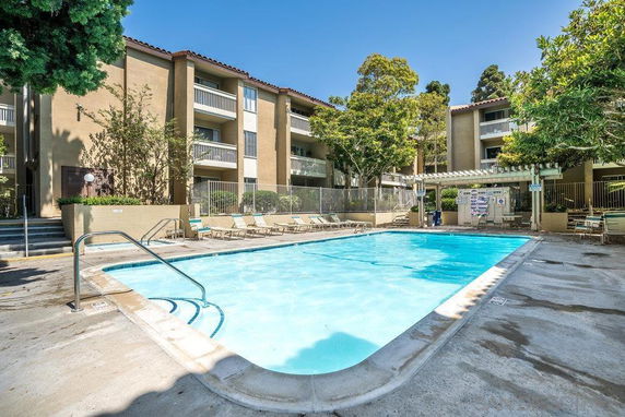 Outdoor swimming pool area with surrounding apartment buildings.