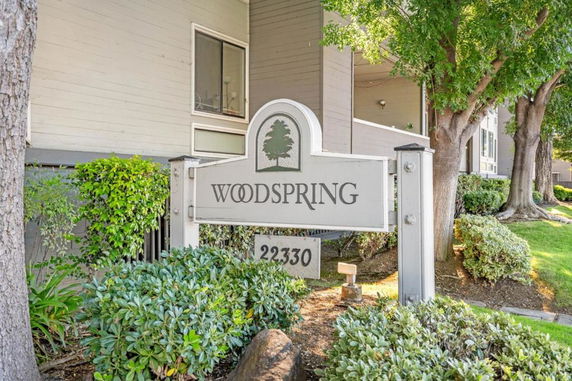 Front view of a building with a sign reading 'Woodspring' and the building number.