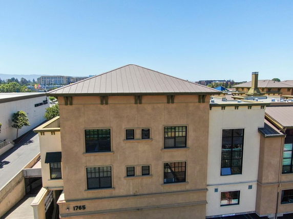 Front view of a multi-story building with a sloped roof.