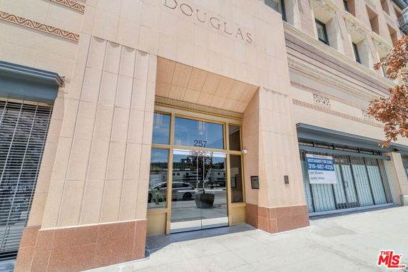 Front view of a building entrance with large glass doors and decorative exterior walls.
