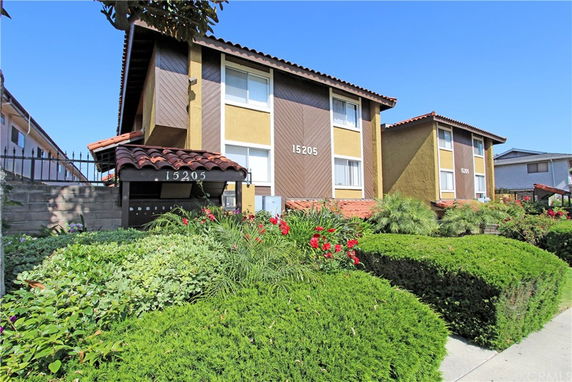Front view of a two-story apartment building with slanted roofs and multiple windows.