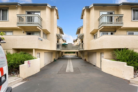 Outdoor parking area between two multi-story apartment buildings.